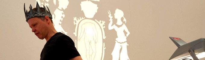 Ein Schauspieler mit Krone vor einem Schattenbild